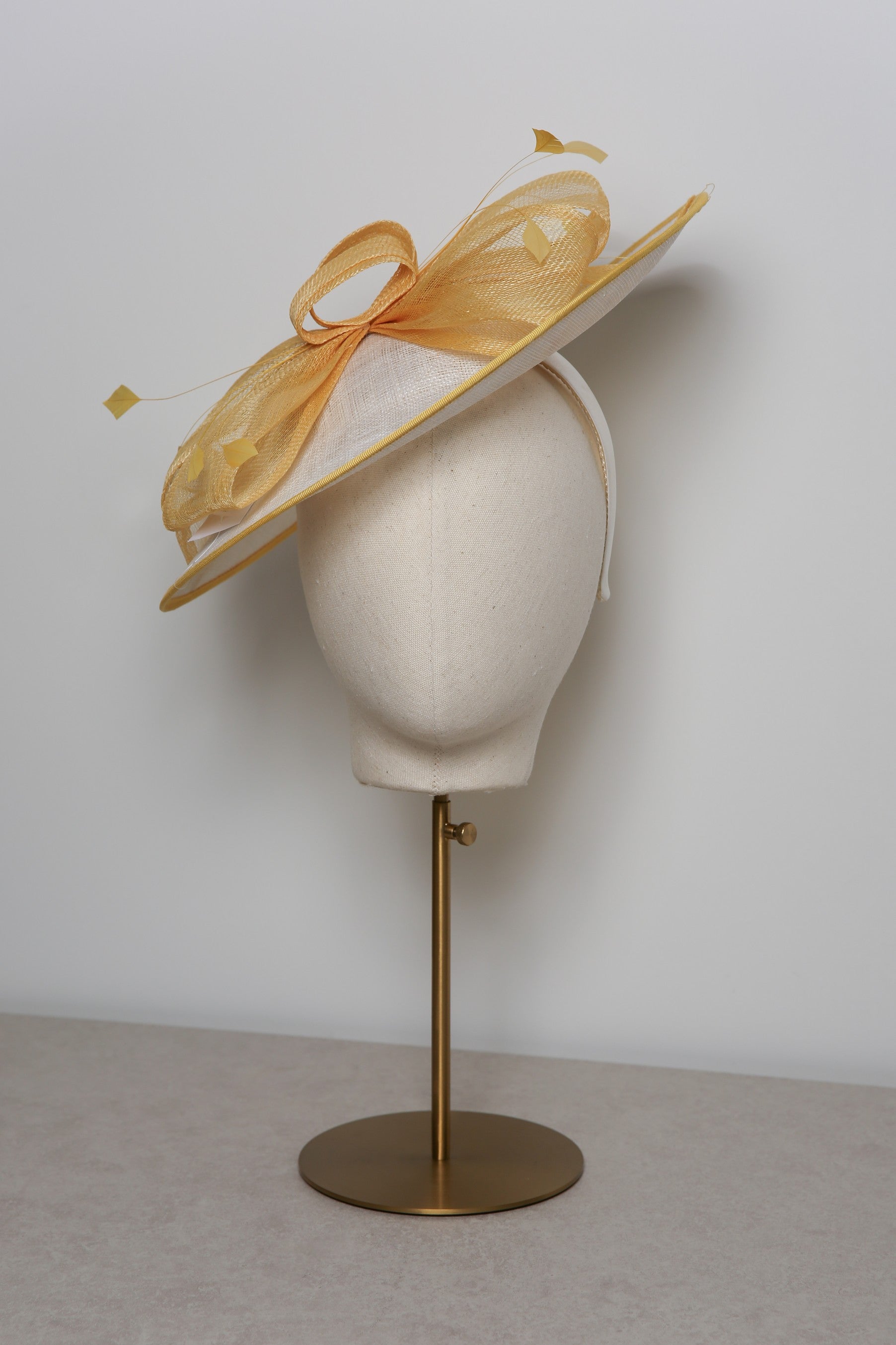 Yellow hat on a mannequin head with a white background