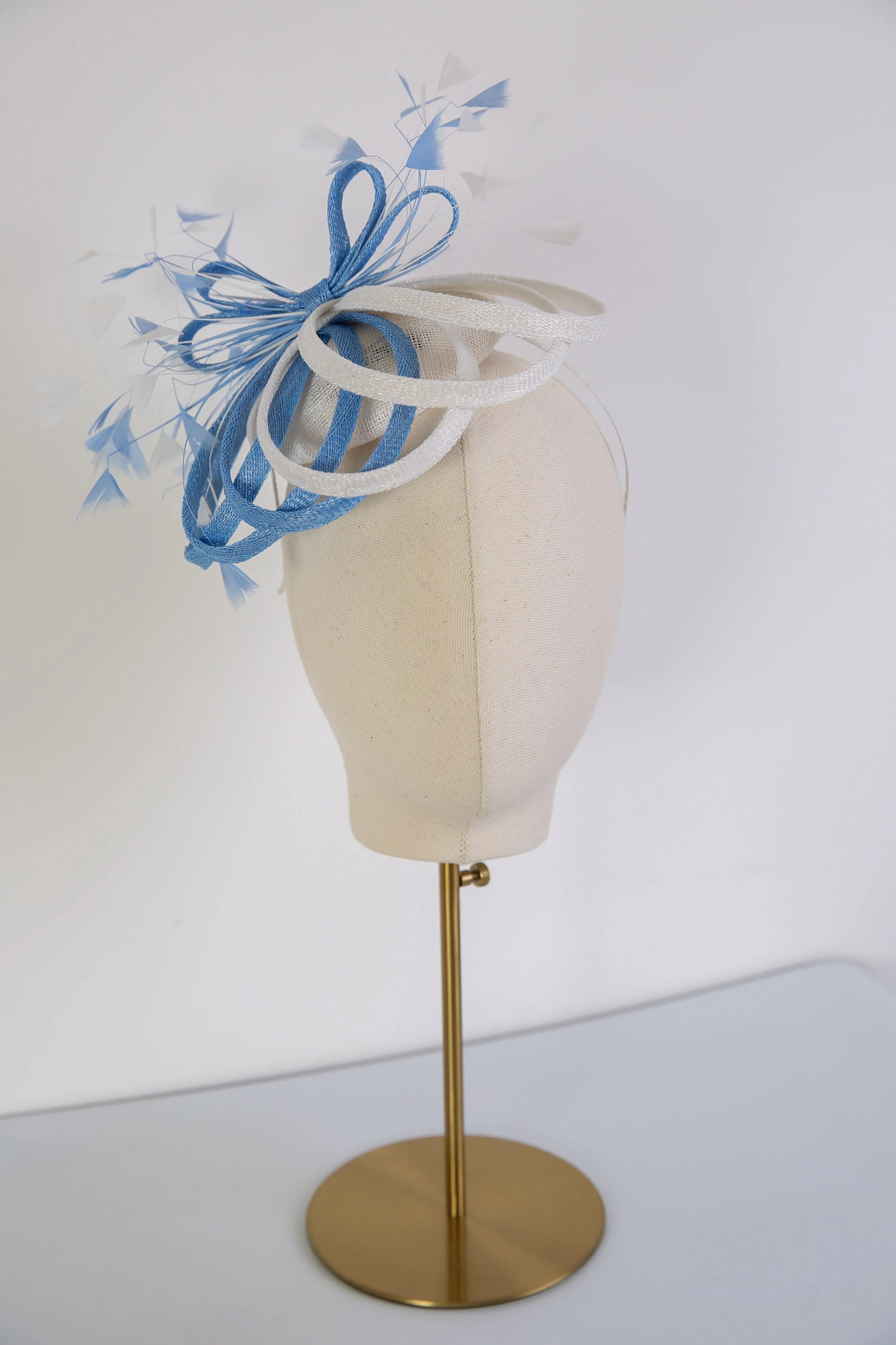 Blue and white decorative headpiece on a mannequin head with a white background