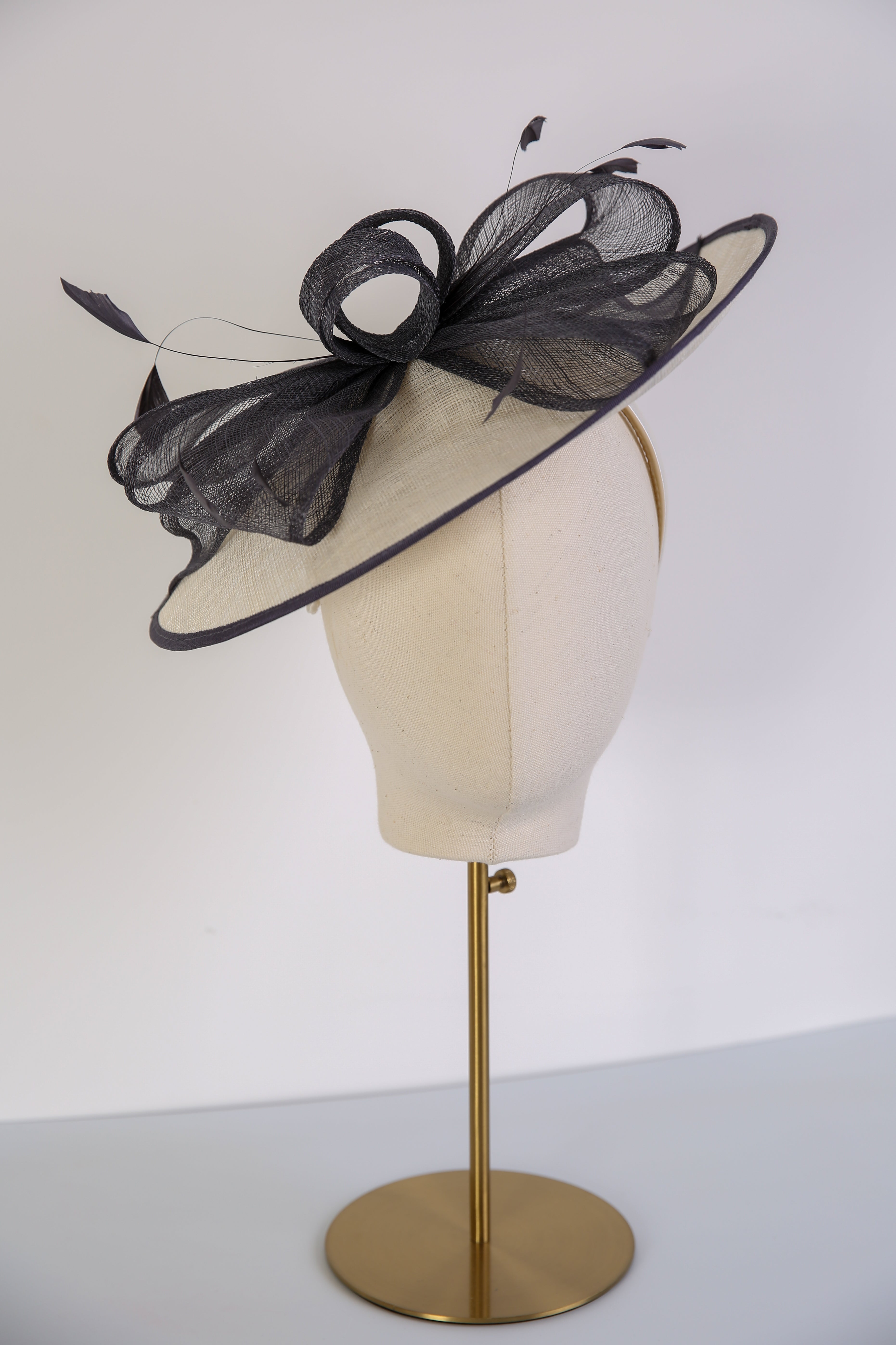 Cream decorative hat with a navy trim. 