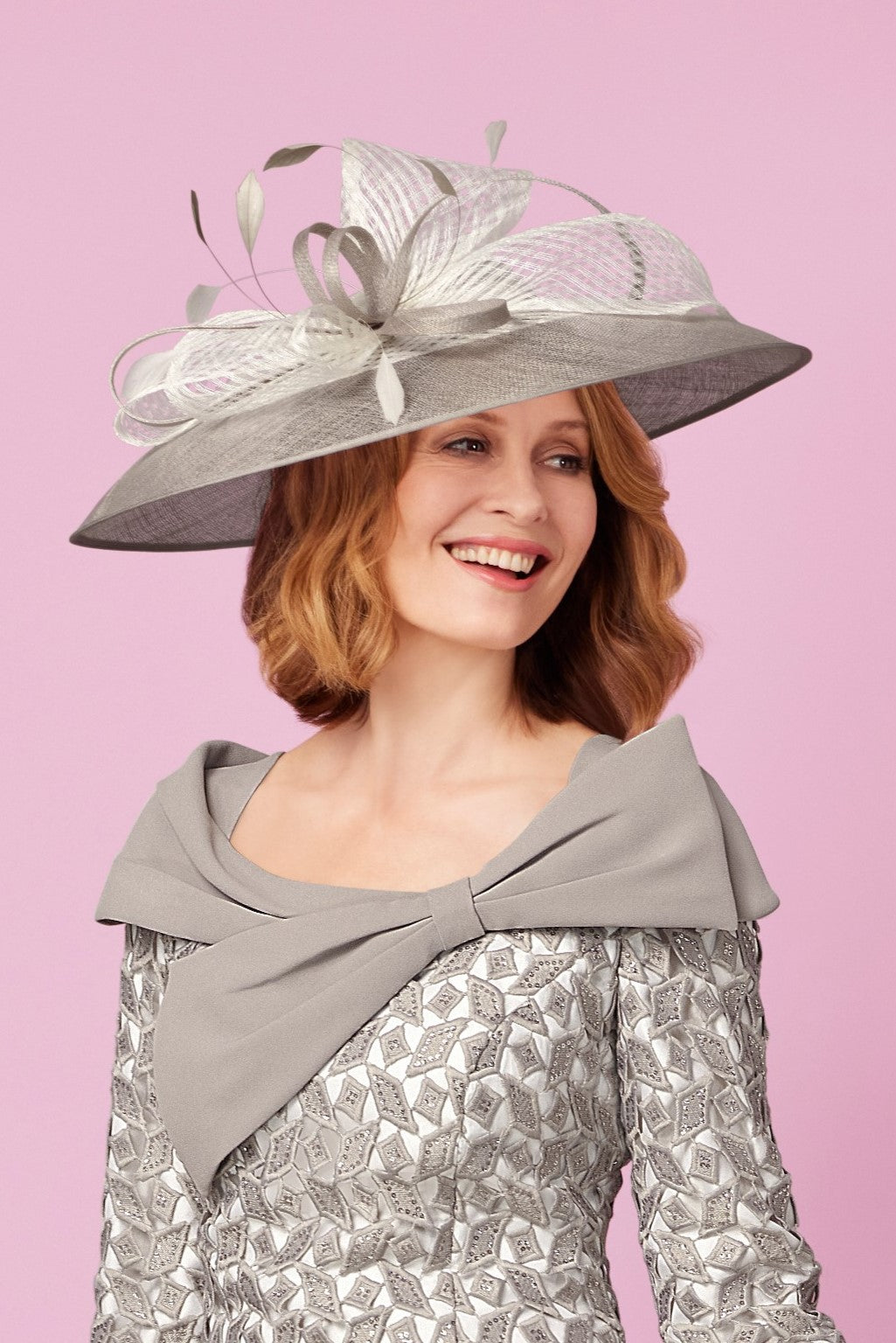 Woman wearing a gray decorative hat with a pink background
