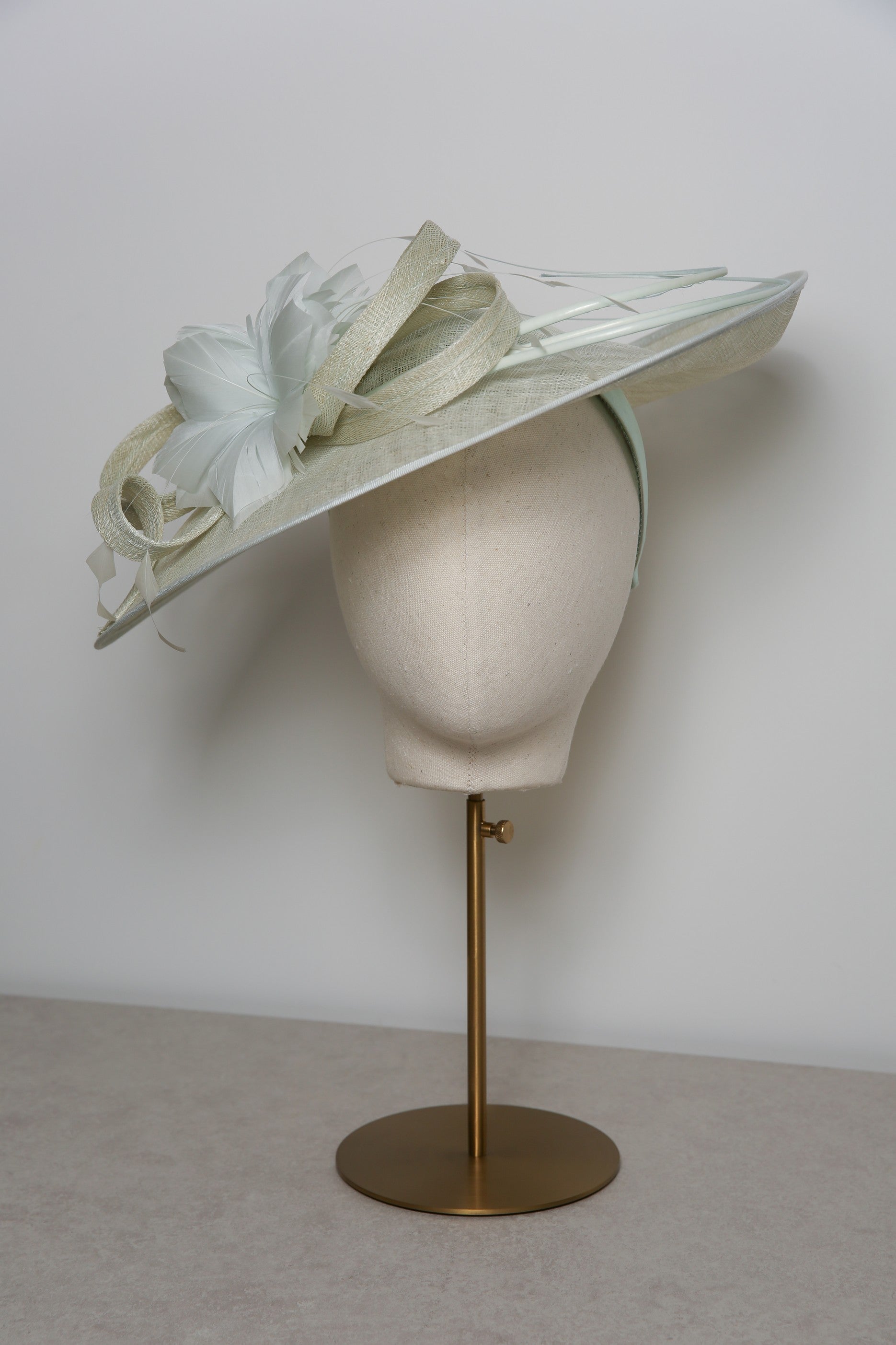White decorative hat on a mannequin head with a white background